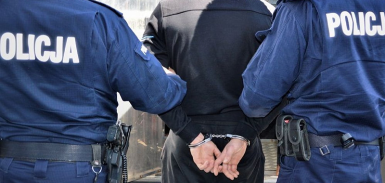 Jeden z zatrzymanych członków grupy przestępczej doprowadzany w kajdankach przez zamaskowanych funkcjonariuszy CBZC do kieleckiej prokuratury.